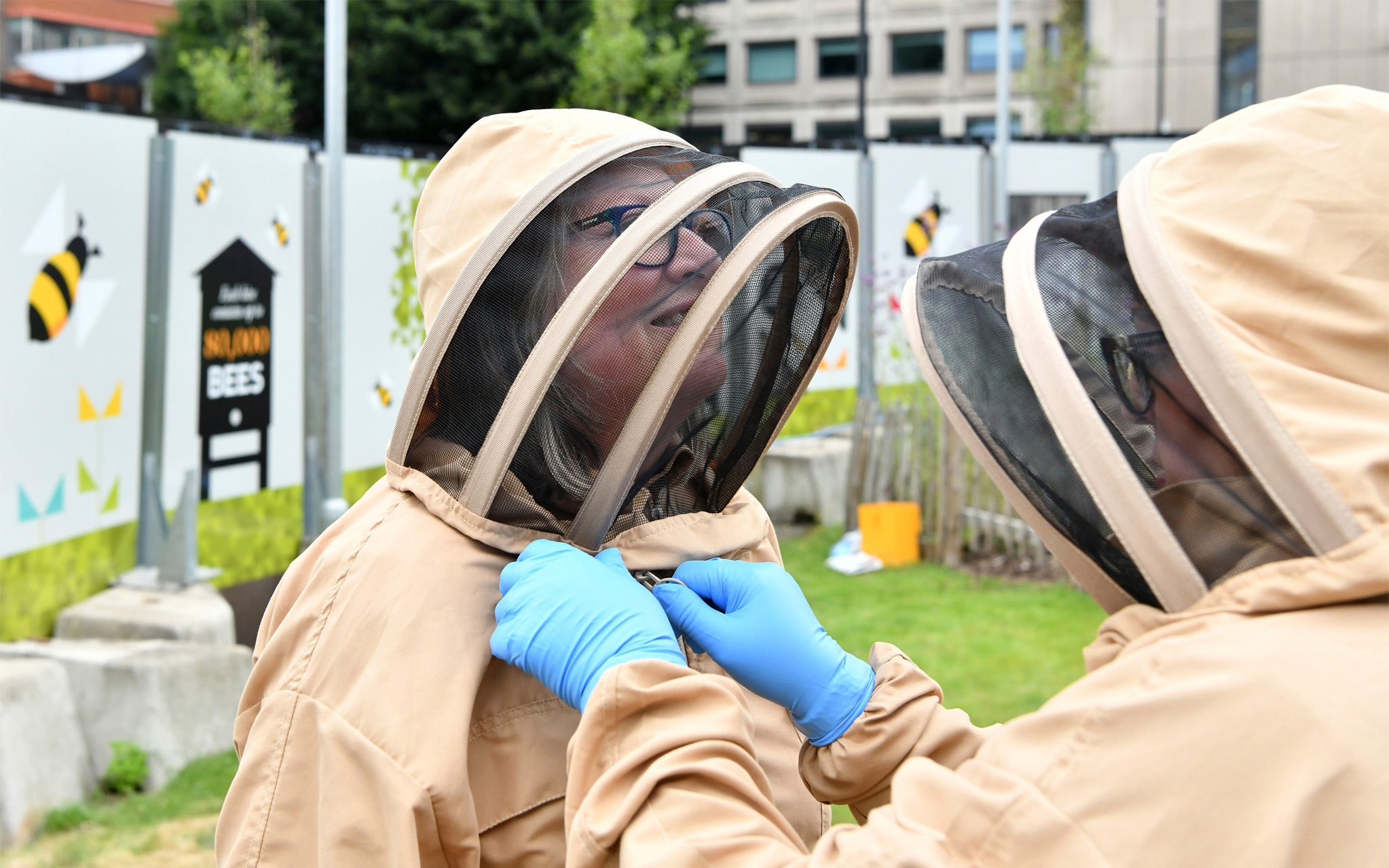 Someone suiting up in a beekeeping suit and checking their helmet.