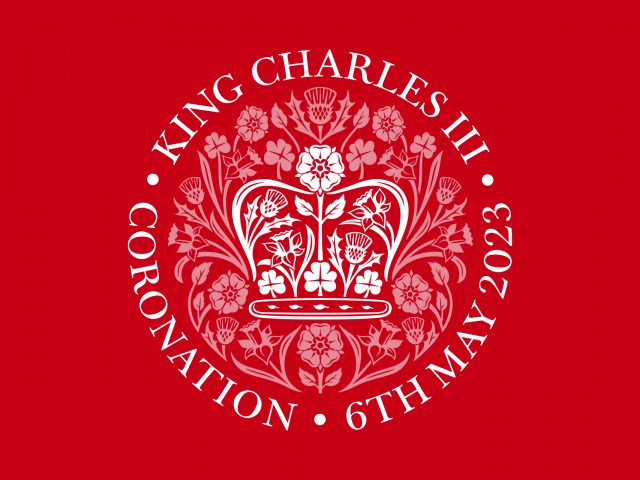 King Charles III Coronation emblem on a royal red background. 6th May 2023.